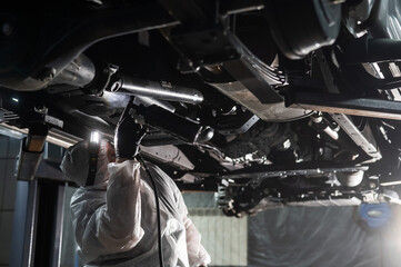 The master sprays an anti-corrosion compound on the bottom of the car. 