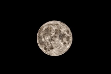 the full moon is glowing in the dark sky while seen