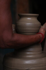 The potter works on a pottery wheel to made of soft colored clay, retro style toned Clay pots with hand and equipment
