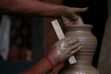 The potter works on a pottery wheel to made of soft colored clay, retro style toned Clay pots with...