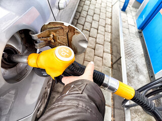Fueling a Car at a Gas Station Pump. Vehicle being refueled with gasoline nozzle at a service station
