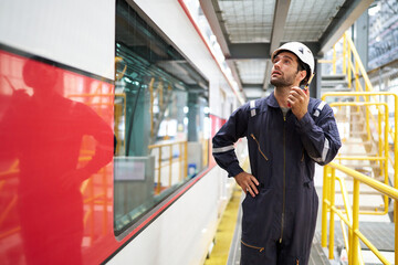 worker using walkie talkie and talking about work at construction train station