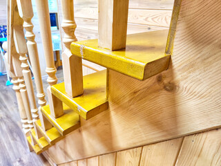 A pine wooden staircase with white balusters in a cozy home. Wooden Staircase in a Rustic Interior Setting