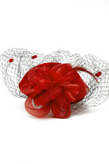 Close-up shot of a red felt pillbox hat with a veil decorated with volume flower, beads and...