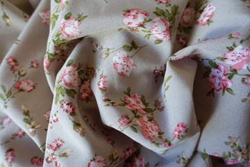Folds on grey rayon fabric with old-fashioned floral print