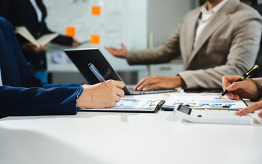 Businessmen team or financial data analysts working with tablets and laptop computers and data...