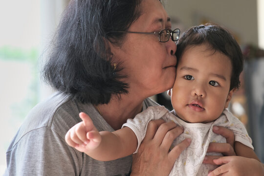 A middle-aged woman kissing her baby boy