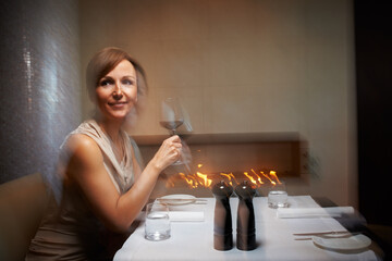 Woman, motion blur and restaurant for dinner, table or wine glass for celebration. Alcohol, intoxicated or drunk on drink for date at night, luxury and party at fine dinning place with glass at event