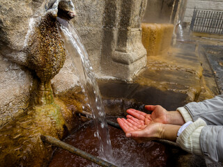 Catching Water from a Historic Stone Fountain