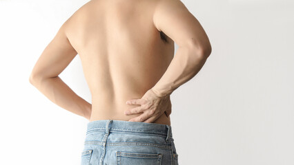 Shirtless man suffering from waist and back pain, with a white background and space for text