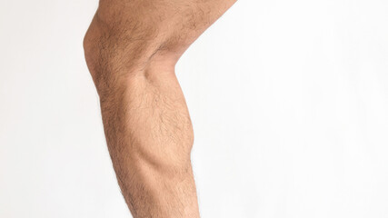 Calf with defined muscle of an adult male with a white background and space for text on the right.