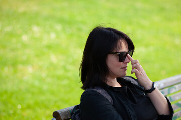 Portrait of a middle-aged woman sitting on a bench in the park