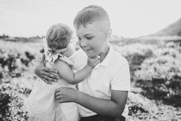 Happy children walk spending time together. Kids playing in mountains on summer day. Daughter hugs...