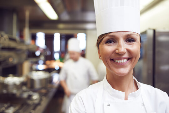Smile, portrait and woman chef in kitchen for cooking meal, supper or dinner with gourmet cuisine. Confident, happy and face of female culinary worker with catering career in restaurant or diner.