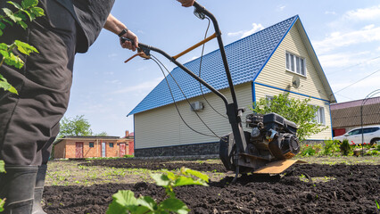 The cultivator processes the chernozem. Farmer cultivating a plot of land before planting...