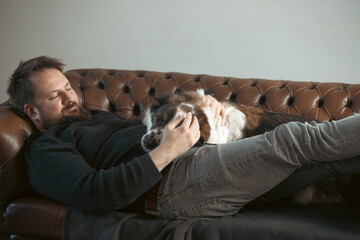 Man sitting on the sofa with his dog.