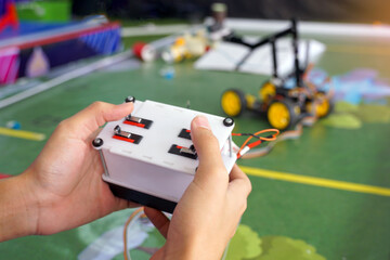 Asian high school students practice moving robots on the playing field To perform missions according to the rules of the robot competition. Soft and selective focus.
