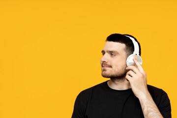 Attractive young guy listening to music in headphones