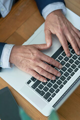 Top view, hands of businessman and laptop for typing in office for email, news research and...