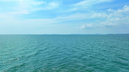 Drone's eye view reveals the deep blue sea merging seamlessly with the vast expanse of a cloudless,...