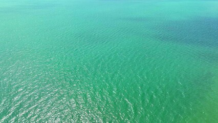 A sea wave, captured from a drone's lofty perspective, dances gracefully, an ode to nature's...