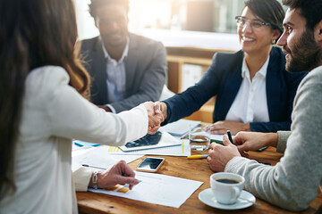 Handshake, women and finance in office for deal, agreement and proposal or interview at desk. Accounting team, collaboration and approved transaction with people at work table, strategy or networking