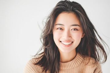 Naklejka premium Beautiful studio portrait of young, stylish asian woman, long hair, smiling and looking at camera with confidence on white background