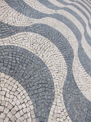 Fototapeta premium Famous sidewalk in Copacabana, Rio de Janeiro, Brazil, with classic Portuguese stones, black and white