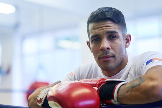 Gym, fighter or man in portrait for workout, exercising and training for competition. Professional, male athlete and break in ring relaxing or resting, commitment and boxer with motivation in sports