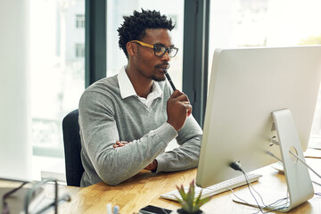 Black man, computer and thinking in office, planning and website for research on article idea. Male...