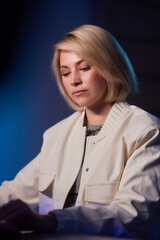 A woman in a white jacket smiles for the camera in formal wear