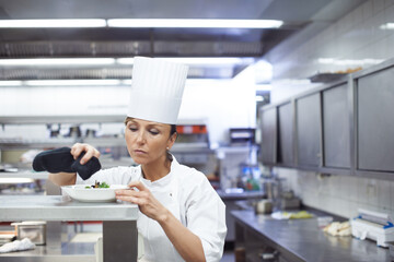Woman, chef and kitchen with dinner plate for hospitality presentation or cooking, cuisine or service. Female person, hat an fine dining food at professional restaurant, nutrition or small business