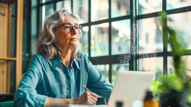 A senior woman executive multitasking with digital tools, exemplifying efficiency and technology in business