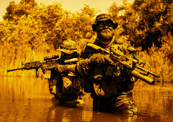 Obraz premium Soldiers move in the heart of a marsh, crossing swampy waters, tropical jungle heat, extreme conditions of concealed tactical combat operations of special task forces