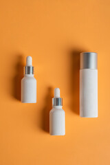 Cosmetic product in tube, bottle, lotion or serum seed on cream background. 