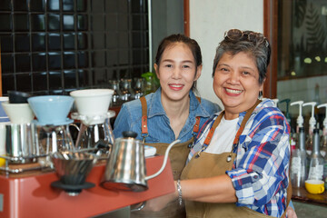 Single Asian businessman, coffee shop owner, retired and receiving pension. cute Asian daughter helping  make coffee at the coffee maker counter. The coffee shop, bakerysmall family business.