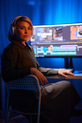 a woman wearing headphones is sitting in front of a computer
