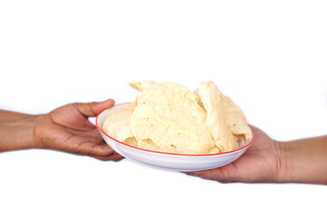 Close up hands holds plate of crisp rice cakes, traditional food. on white background.  Concept, giving , serving and sharing food. Traditional Thai snack, made from dried dough and deep fry.
