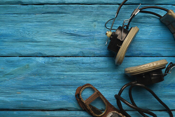 Retro style pilot goggles and headset on the blue sky concet background with copy space.