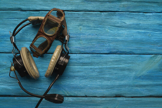 Retro style pilot goggles and headset on the blue sky concet background with copy space.