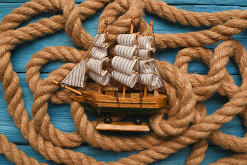 Columbus day concept background. Toy ship on the moorings rope flat lay background. - obrazy, fototapety, plakaty
