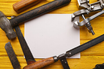 Construction to do list template. Empty blank paper sheet and work tools on the yellow flat lay workbench background.