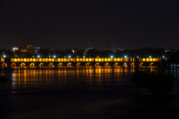 Fototapeta na wymiar the beautiful view of the city of Isfahan and the zayandeh rud River at night and the thirty-three bridge (siose pol) of this city, which have a special view at night with lighting