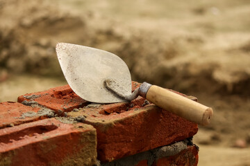 Trowel on a brick wall, closeup of photo.
Construction background wallpaper with mason tools