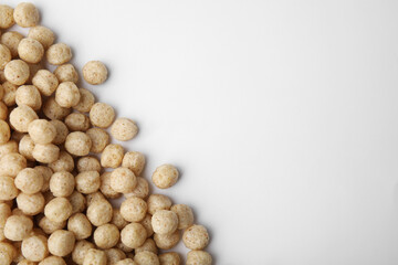 Tasty cereal balls on white background, flat lay