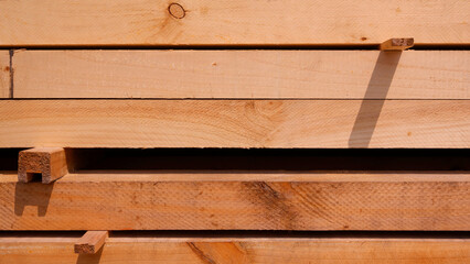 Rows of big hardwood timbers stacked in horizontal pattern, wood construction material background