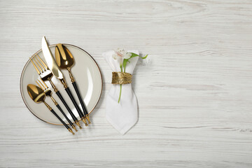 Stylish setting with elegant cutlery on white wooden table, top view. Space for text