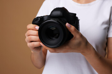 Photographer with camera on brown background, closeup