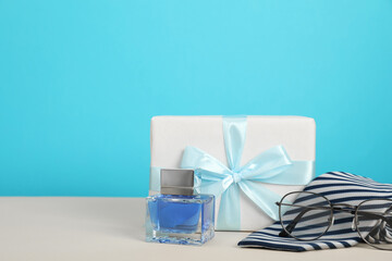Happy Father's Day. Tie, glasses, perfume and gift box on beige table, closeup. Space for text