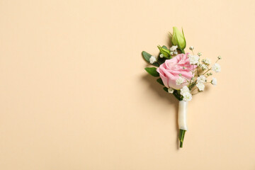 Wedding stuff. Stylish boutonniere on beige background, top view. Space for text - obrazy, fototapety, plakaty